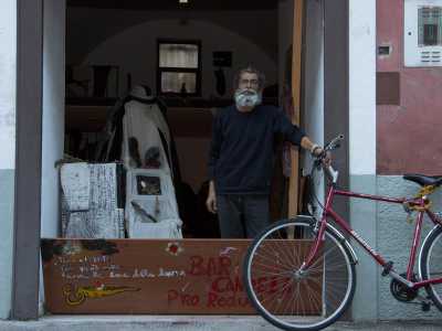 E subito dietro l'uscio, mentre mantiene la sua fedele bicicletta rossa, c'� proprio il barbuto Paolo, il "padrone di casa"